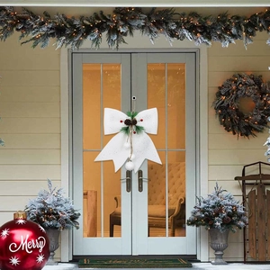 White Christmas bow with pine cones and berries for festive front door decoration