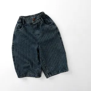 Détail de short en jean rayé pour enfant avec taille élastique et bouton décoratif