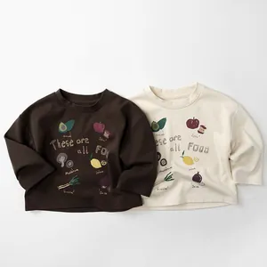 Detail von Kinder-Langarmshirts aus Baumwolle mit Illustrationen von Lebensmitteln und Text