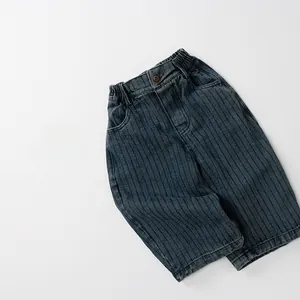 Détail du jean rayé pour enfant avec taille élastique et bouton au style vintage