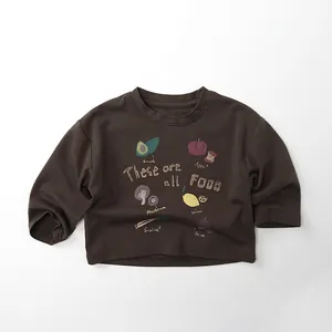 Detail eines Baumwoll-Kinder-Sweatshirts mit bunten Lebensmittel-Illustrationen und Text