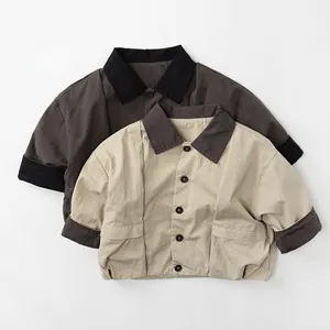 Detail of children's cotton jacket showing contrast collar, buttons and utility pockets