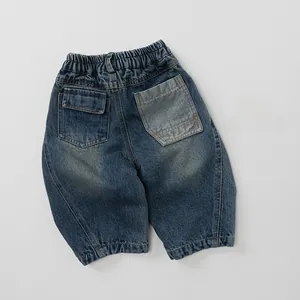 Dettaglio dei pantaloni in jeans per bambini con vita elastica e tasca a contrasto