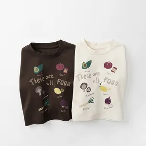 Flach liegende Kinder-Langarmshirts aus Baumwolle mit handgezeichneten Obst- und Gemüsedrucken