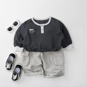 Dettaglio di una maglietta Henley grigia a maniche lunghe e pantaloncini cargo