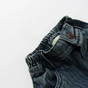 Détail de jean pour enfant montrant la taille élastique et le bouton marron vintage