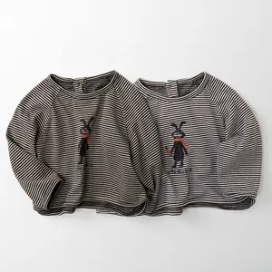 Detail view of two children's striped cotton shirts featuring cute rabbit prints