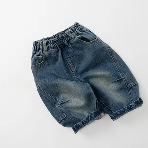 Dettaglio dei pantaloni in denim per bambini con elastico in vita e cuciture gialle
