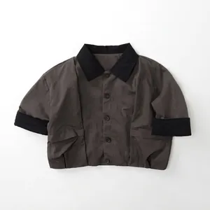 Detail of dark grey short-sleeved jacket with contrast black collar and button closure