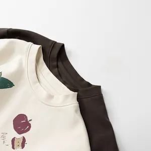 Detail von Rundhalsausschnitt und Baumwollstoff bei Kinder-T-Shirts mit Apfel-Print