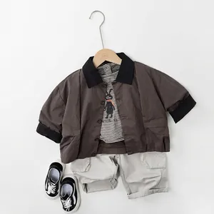 Flat lay of kids brown collared shirt, striped rabbit T-shirt and grey cargo shorts set