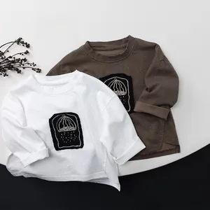 Detail showing two cotton long-sleeve t-shirts in white and dark brown colors