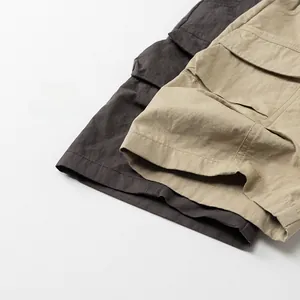 Detail of kids casual cargo pants in dark grey and khaki with large side flap pockets