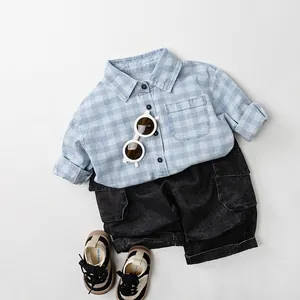 Kids casual blue checkered shirt and black cargo shorts outfit flat lay presentation