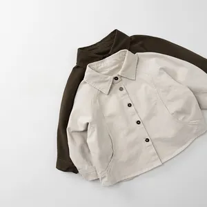 Flat lay detail of kids long sleeve cotton shirts in beige and dark coffee colors