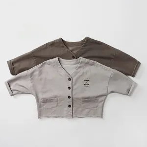 Flat lay of brown and grey kids knit cardigans with apple graphic and V-neck detail