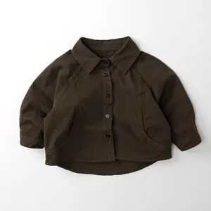Detailed flat lay of dark brown long sleeve kids shirt with buttons and curved hem
