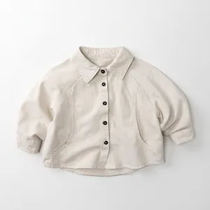 Detail view of cream long sleeve kids jacket with black buttons and a lapel collar