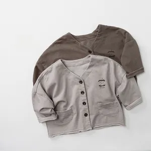 Detailed view of kids cotton cardigans with V-neck, double pockets and apple prints