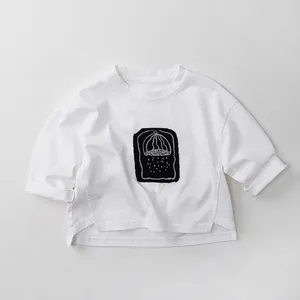 Detail of white cotton long-sleeve kids T-shirt with black graphic print and side slit