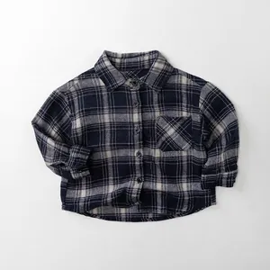 Détail à plat d'une chemise à carreaux pour enfants au motif bleu marine et crème