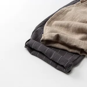 Détails du pantalon rayé en lin avec ourlets repliés et texture de tissu naturelle