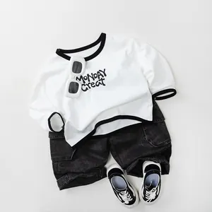 Dettaglio di t-shirt in cotone per bambini e pantaloncini cargo in denim in flat lay