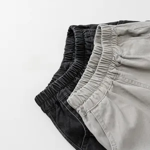 Dettaglio della vita elastica su pantaloni cargo per bambini in nero e grigio