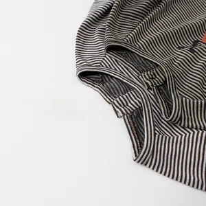Detailed close-up of the fine stitching and soft cotton striped fabric on the sleeve cuff