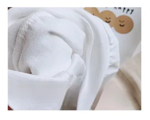 Detalle de cerca de la tela de algodón blanco suave y costuras de una camiseta para niños