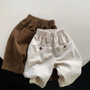 Detailed texture of kids corduroy pants with elastic waist and decorative buttons