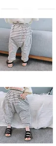 Détail du pantalon sarouel rayé noir et blanc pour bébé dans un décor intérieur