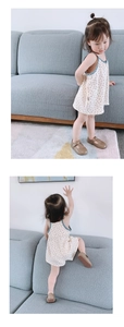 Toddler girl polka dot strap romper with brown T-strap leather shoes in a cozy home setting