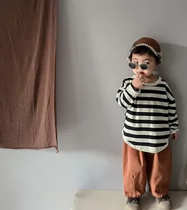 Detail showing kids loose brown trousers and striped t-shirt for autumn fashion