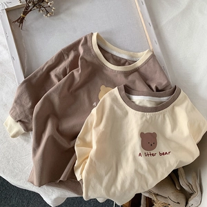 Gros plan sur les poignets côtelés et le coton doux des t-shirts enfant à motif ours
