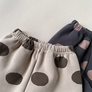 Detail of high elastic waistband and polka dot patterns on kids warm trousers