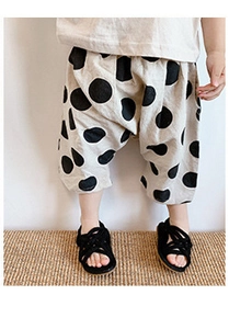 Detail of loose fitting cotton-linen harem shorts for girls with black polka dot pattern