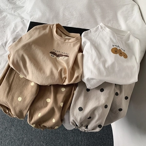 Vista plana de dos conjuntos de camisetas de algodón de manga larga para niños y joggers