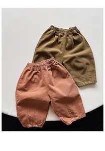 Detail of loose-fit cotton linen kids' trousers with elastic waist and ribbed cuffs