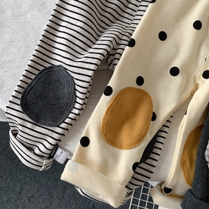 Detailed view of cotton leggings showing stripe and polka dot patterns with knee patches