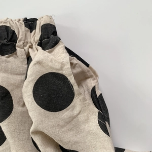Vue macro détaillée de la taille élastique et de la poche latérale du pantalon à pois
