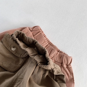 Detail of elastic high-waist and utility pockets on soft cotton kids casual trousers