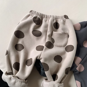 Detail of children's polka dot trousers featuring thick fleece lining and elastic waist