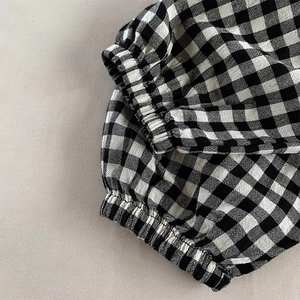 Détail du pantalon vichy pour enfant montrant l'ourlet élastique et la texture du tissu