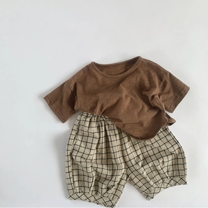 Detailed flat lay of children cotton linen set with brown tee and checkered shorts