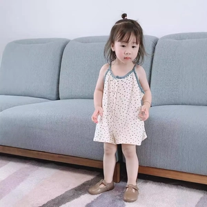 Cute baby girl polka dot summer romper with blue trim straps on a white cotton base