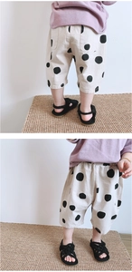 Detail of girls summer polka dot pants paired with a purple cotton t-shirt in casual style
