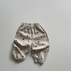 Détail de la taille élastique et des pois noirs sur un pantalon kaki pour enfant