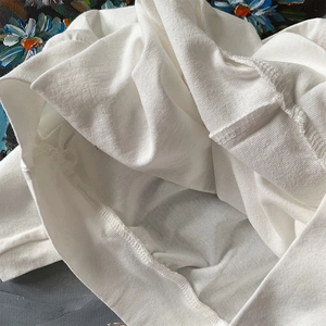 Primer plano detallado de la tela de algodón blanco con costuras y textura de alta calidad