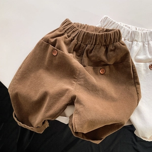 Detail of children corduroy pants featuring elastic waist and decorative buttons
